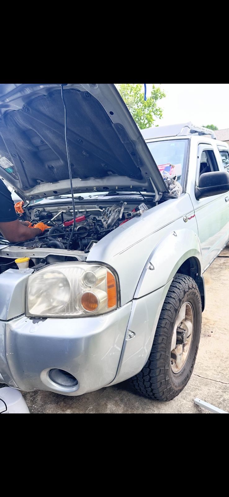 A mechanic repairing a vehicle in an Orlando driveway